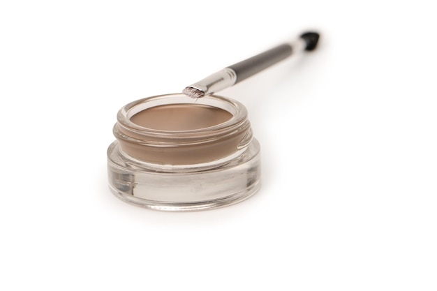 A brow pomade in blonde shade with brush isolated on a white background