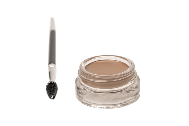 A brow pomade in blonde shade with brush isolated on a white background