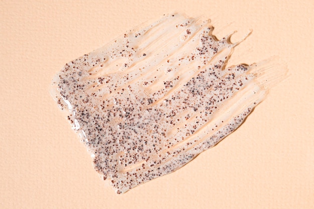 Brown body scrub on a beige background Sample cosmetic product closeup top view