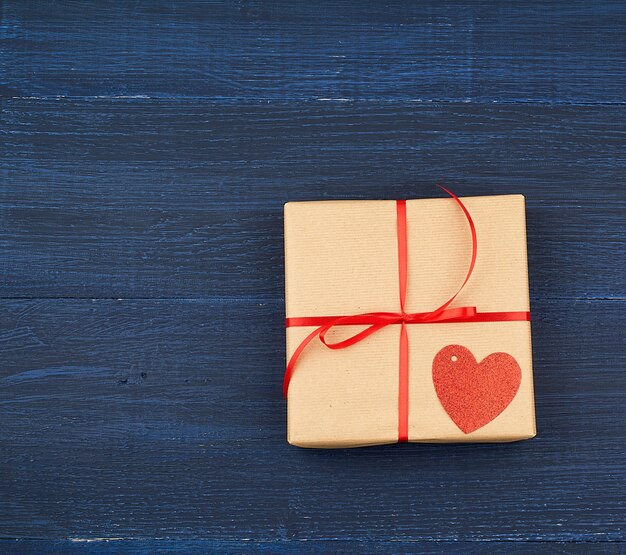 Brown box with a gift and a red paper heart