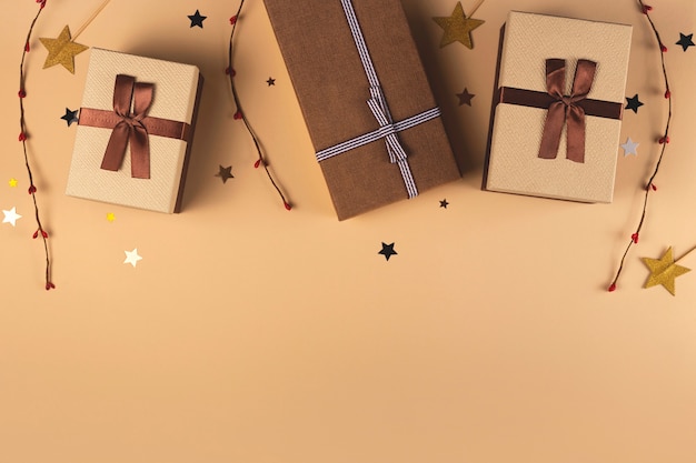 Brown boxes with ribbons  Christmas gifts on a neutral background with stars and twigs Top view flat lay copy space