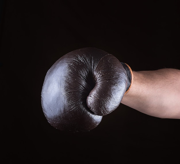 Brown boxing glove dressed on man's hand