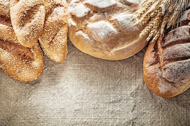 Brown bread breadstick wheat ears on hessian background