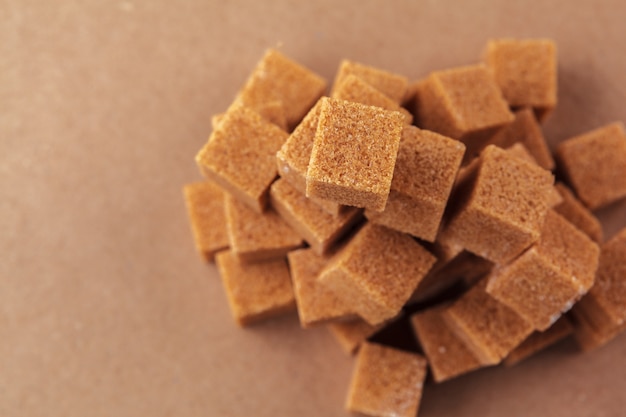 Brown cane sugar cubes on a light brown 