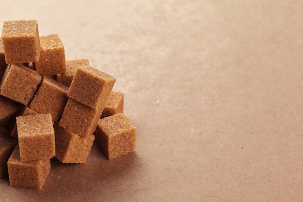 Brown cane sugar cubes on a light brown 