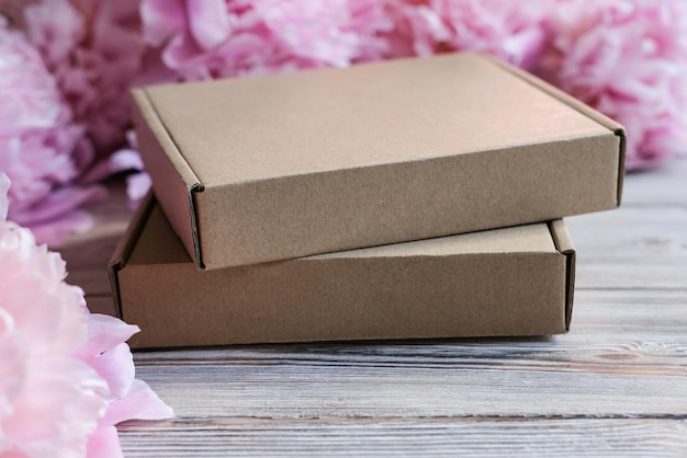 Brown cardboard boxes and peony flowers Package box for branding Mock up gift boxes