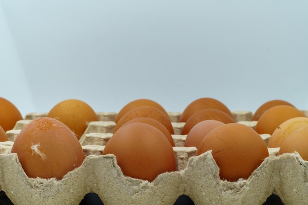 Photo brown chicken eggs in a carton eggshells have small blemishes and feathers indicating a natural farmfresh origin