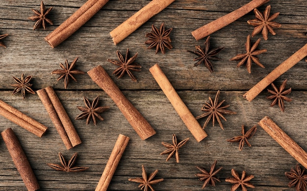 Photo brown cinnamon sticks and dry star anise on a gray wooden background