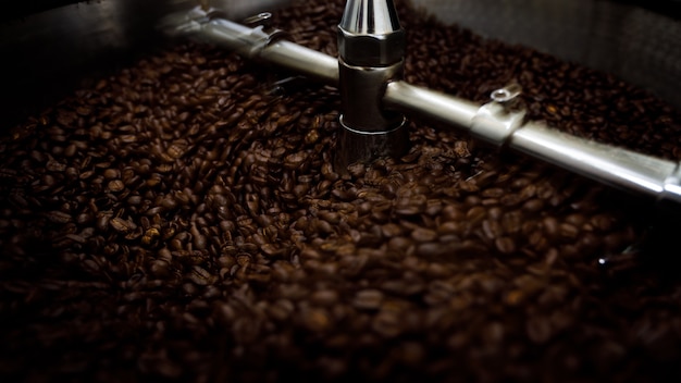 Photo brown coffee beans in roasting spin machine close up sport focus and long exposure shot