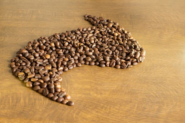 Brown coffee grain on a wooden background closeup