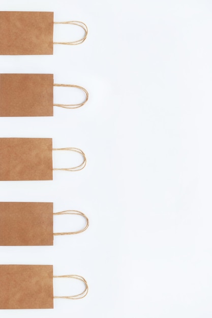 Brown craft bags for shopping on a white background in a row