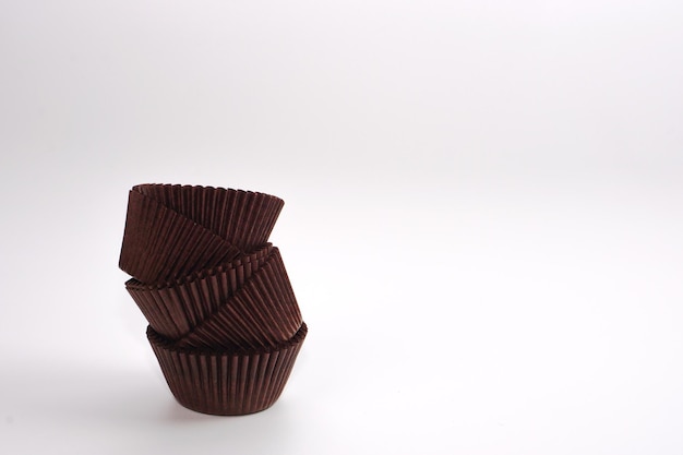 Brown cupcake cases on white background Material for baking.