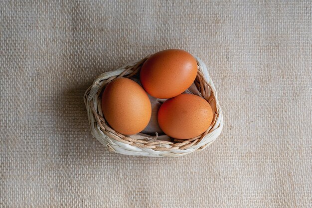 Brown eggs in a basket on a background of burlap