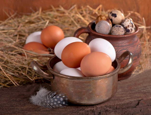 Brown eggs in wooden basket. Broken egg with yolk in background.