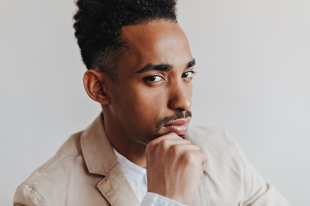 Brown-eyed man in jacket and shirt looking at camera