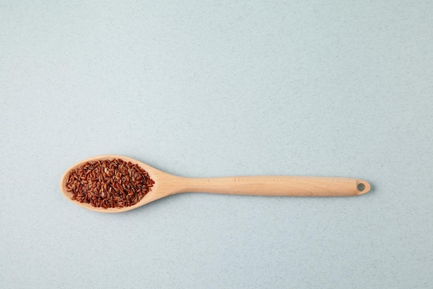 Brown GABA rice in long wooden spoon top view Selective focus copy space