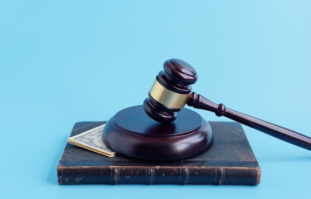 Brown gavel and dollars on a blue background with