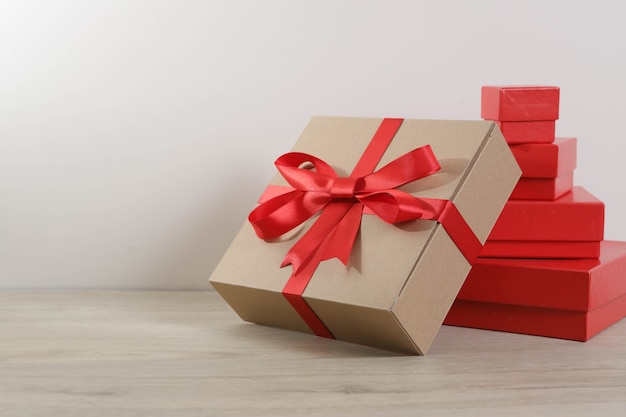 Brown gift box and red ribbon on wooden table