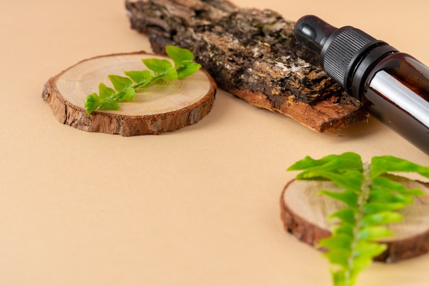 Brown glass cosmetic bottle, tree bark and leaves