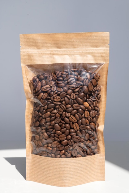 Brown kraft paper bag with coffee beans for viewing with a highlighted shadow on a white background