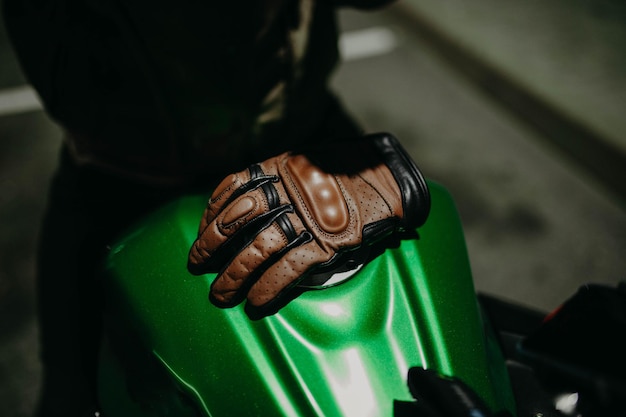 brown leather motorcycle gloves on the tank of a motorcycle