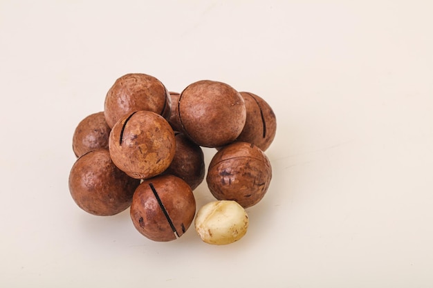 Brown macadamia nut heap over background