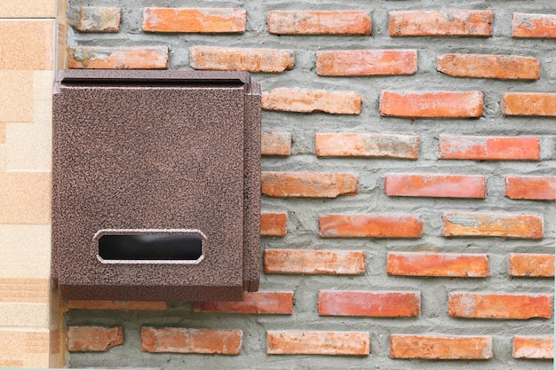 Brown Mailbox on brick wall.