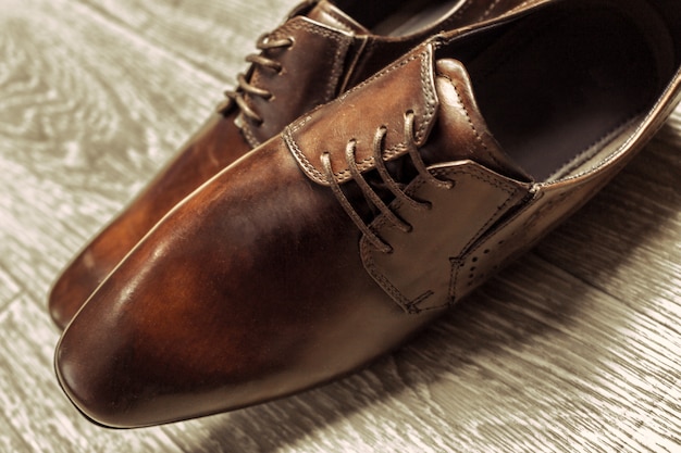 Brown male shoes on wooden floor