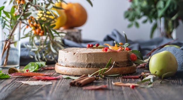 Brown mousse cake decorated with autumn leaves and berries