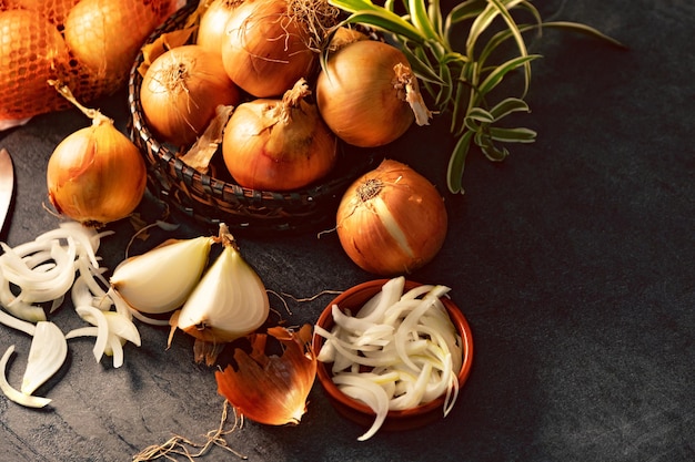 Brown onions and slices on wooden cutting board.Healthy food background.