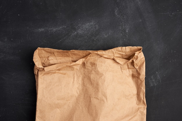 Brown paper bag on a black space, top view