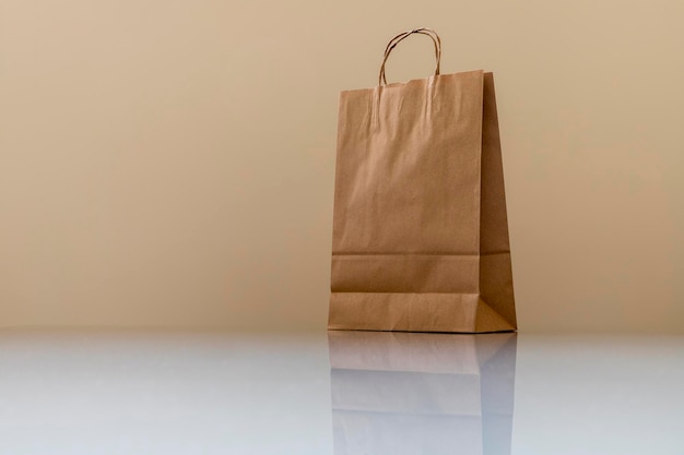 Brown paper bag on white glass table Space for text