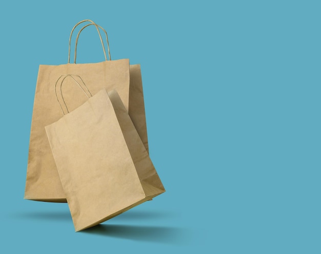 Brown paper bags on blue background Copy space