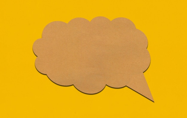 Brown paper speech bubble on yellow paper background