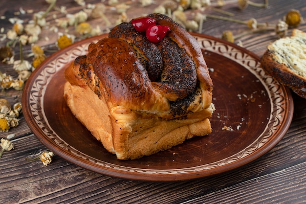 Brown plate of fresh pastry with chocolate sauce on wooden table. 