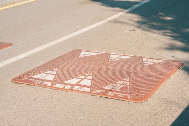 Brown rectangular speed bump installed on the road City Jump Safety Traffic Lying Bumpy Ramp Roadway Mark Pass Protection Transportation Stop Surface Danger