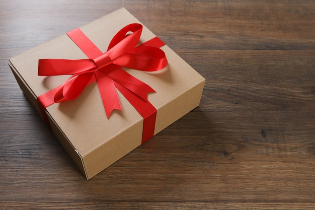 Brown and red gift boxes and red ribbon on wooden table