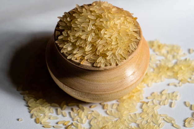 Brown rice isolated on white background in wooden pot