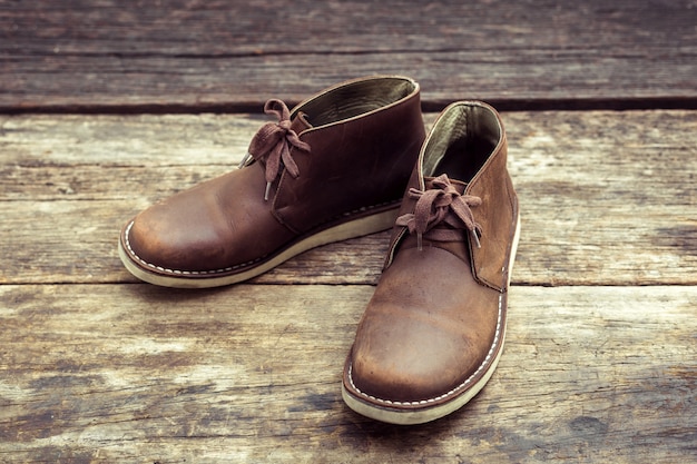 Brown stylish boots on wood, retro color