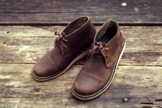 Brown stylish boots on wooden floor