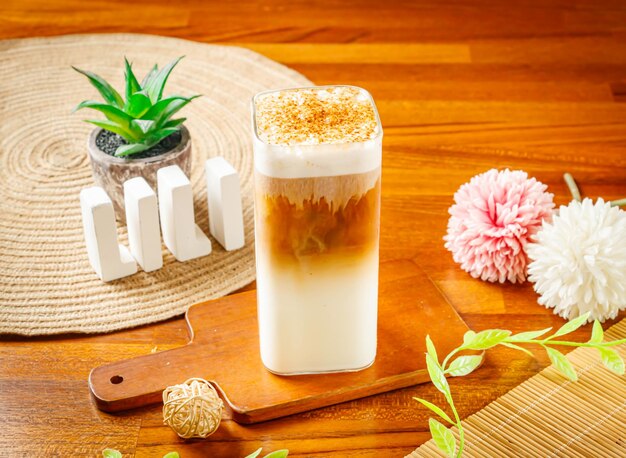 Photo brown sugar iced latte served in glass isolated on wooden table side view of taiwan drink