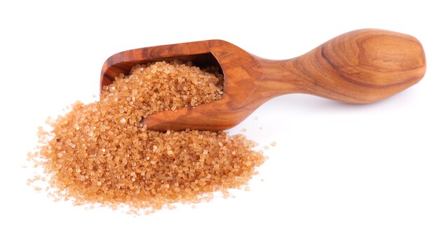 Brown sugar in wooden scoop isolated on white background heap of cane sugar crystals