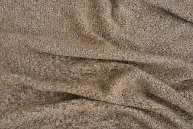 Brown textured background made of handknitted natural wool yarn Warm cozy knitted clothes texture