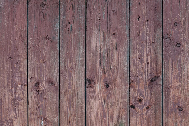 Brown vertical planks with knots and chipped away paint