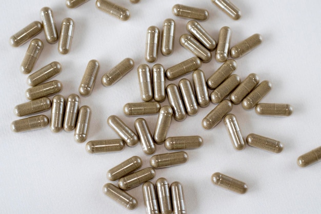 Brown Vitgrass capsules on a beige background Supplements medicines and pills