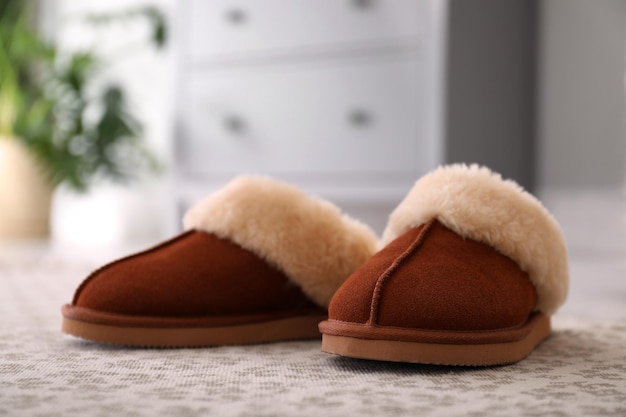 Brown warm slippers on floor in room