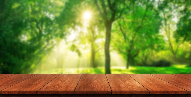 Brown wood table in green blur nature background.