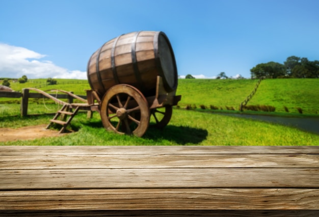 Brown wood table in vineyard landscape with empty copy space on table for product display mockup.