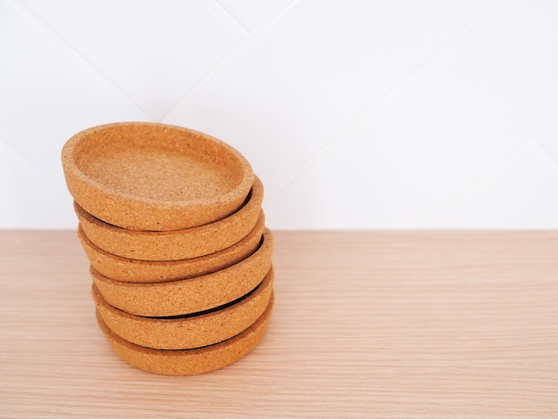 Brown wooden coasters stacked on kitchen table