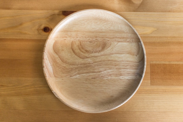 Brown wooden plate on wood table background